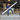 A man playing an 8 foot LED strip light like an air guitar standing in front of a small warehouse